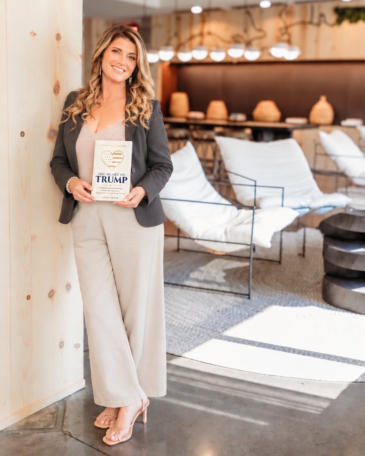 Author Leah Speer holding The Heart of Trump: Golden Age Edition